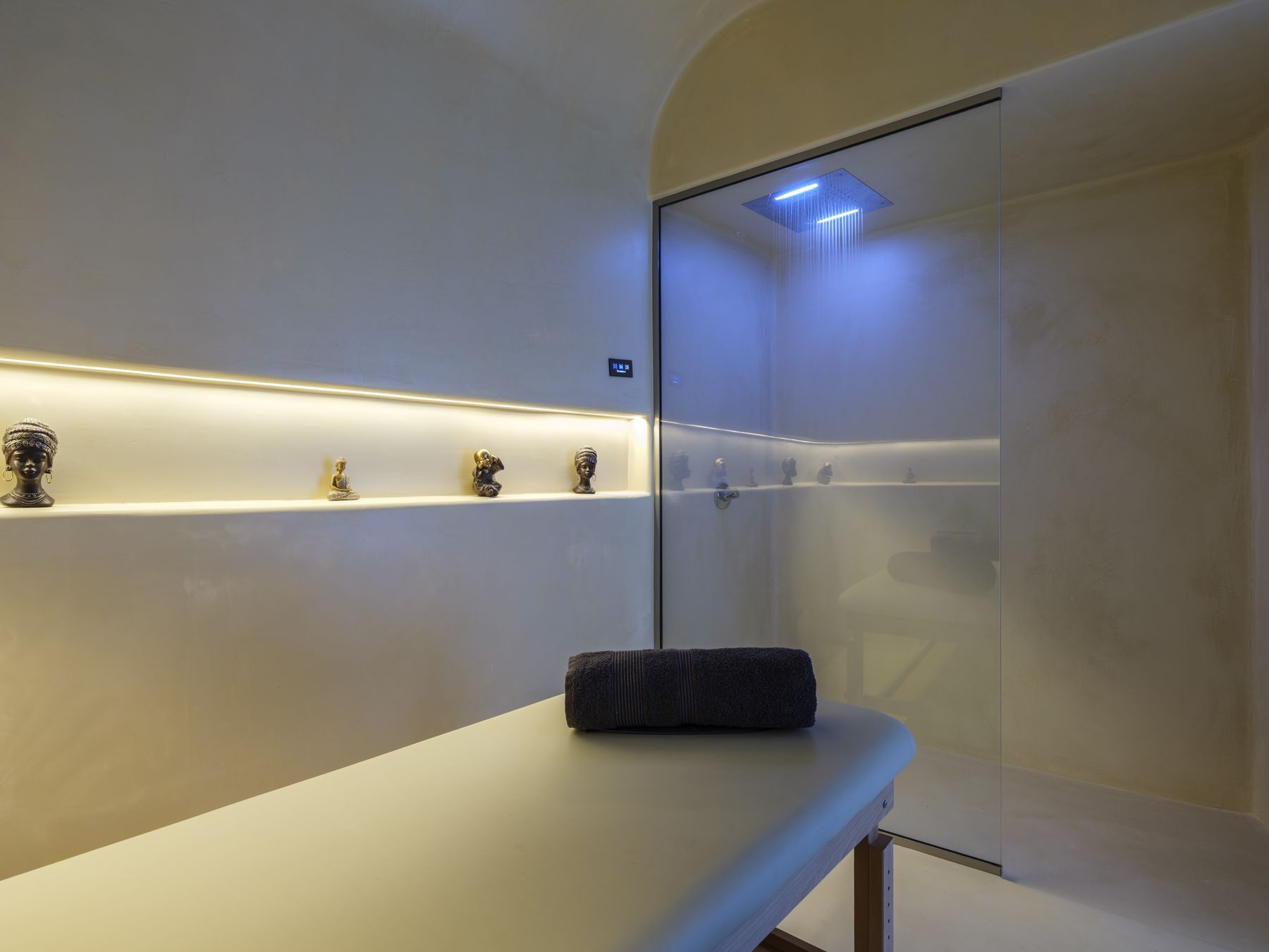 Massage room with massage table and chromotherapy shower